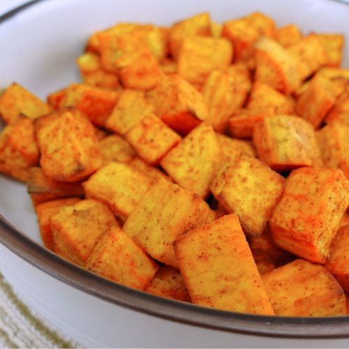 Golden-brown fried sweet potato cubes served hot.