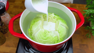 Cabbage leaves cooking in milk in a pan