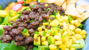 Close-up of vibrant taco salad ingredients in a bowl.