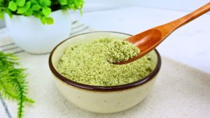 Homemade pumpkin seed flour in a measuring spoon close-up.