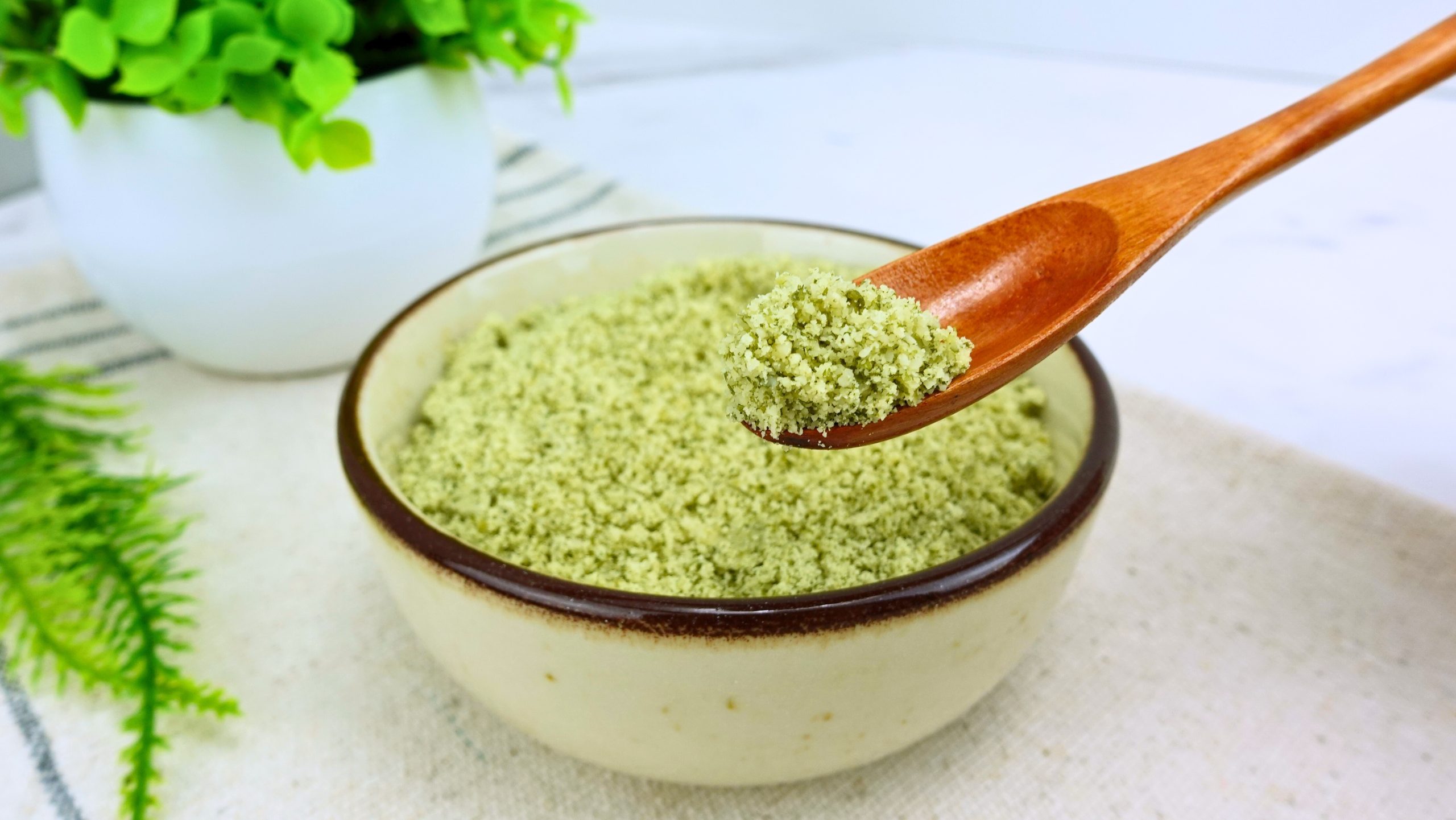 Homemade pumpkin seed flour in a measuring spoon close-up.