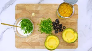 Fresh ingredients for creamy cilantro dressing including herbs, lime, and yogurt.