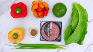 Ingredients for taco salad with creamy cilantro dressing arranged on a counter.