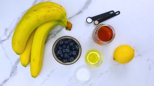 Ingredients for vegan blueberry banana ice cream on a countertop.