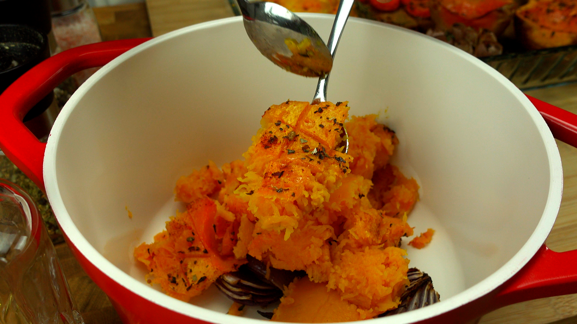 Scooping cooked butternut squash from the skin