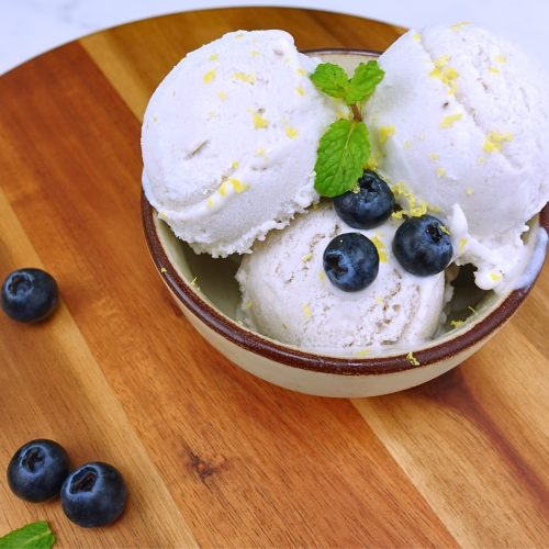 Serving blueberry banana ice cream garnished with mint leaves in a bowl.