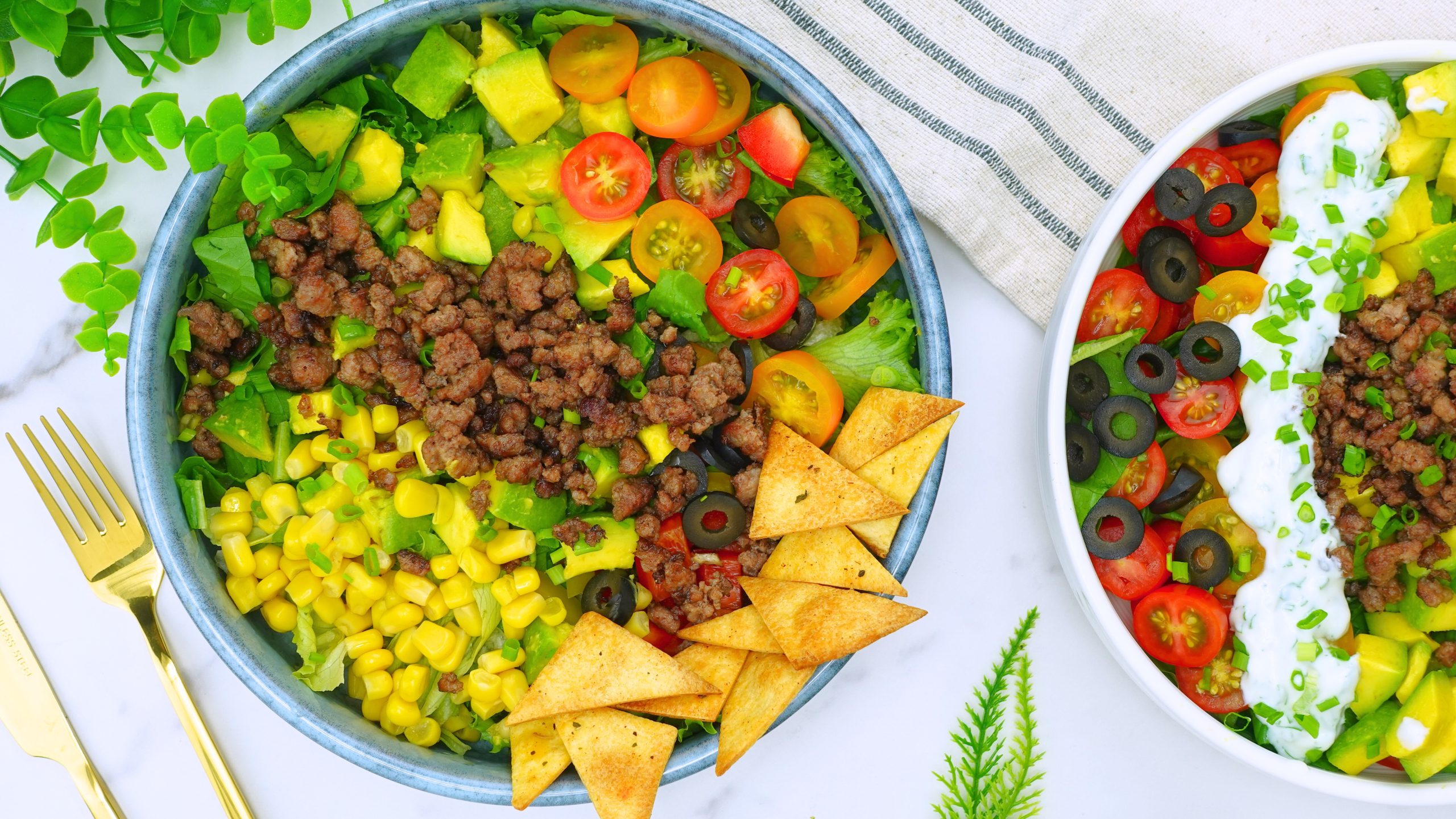 Serving taco salad with creamy dressing in a white bowl.