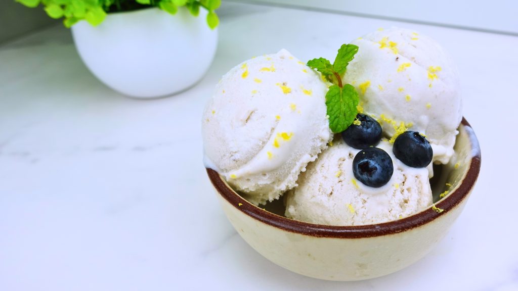 Close-up of creamy vegan blueberry banana ice cream garnished with fresh berries.