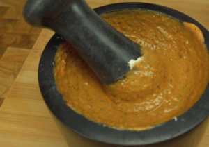 Adding balsamic cream, yogurt, Dijon mustard, and tomato sauce to a mortar.