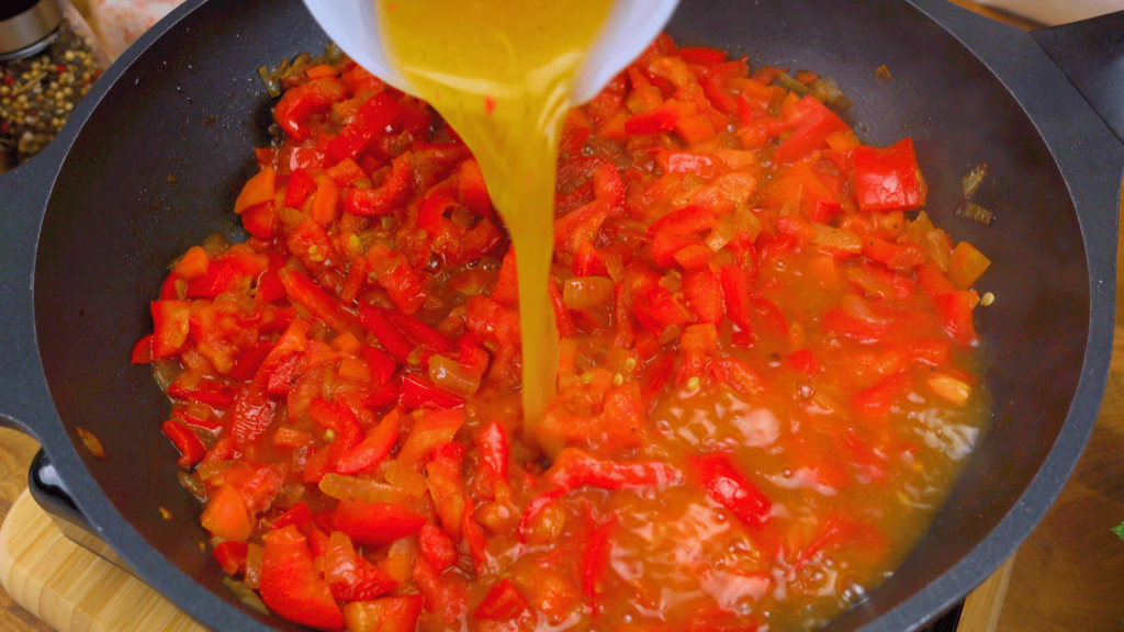 Adding broth to the sauce mixture