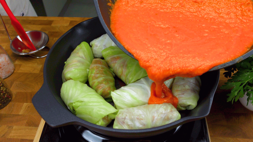 Pouring tomato sauce over golumpki