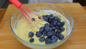Adding blueberries to muffin batter.