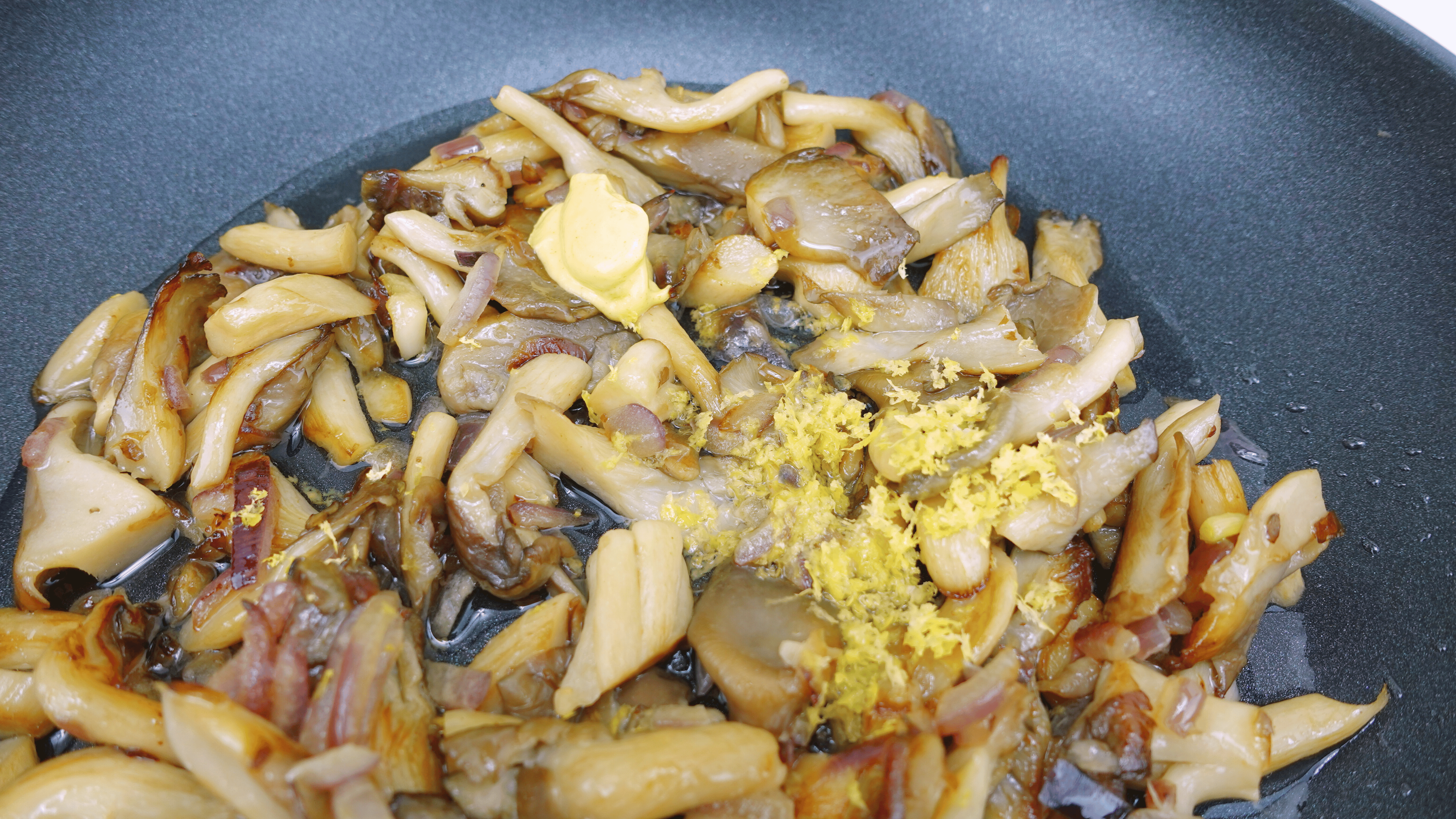 Adding lemon zest to mushrooms.