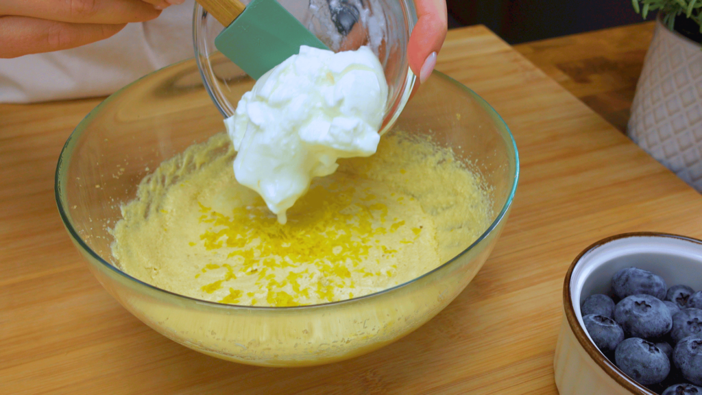 Adding yogurt to the muffin batter.