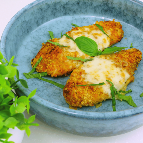 Chicken Alfredo served with sauce and basil, ready to eat.