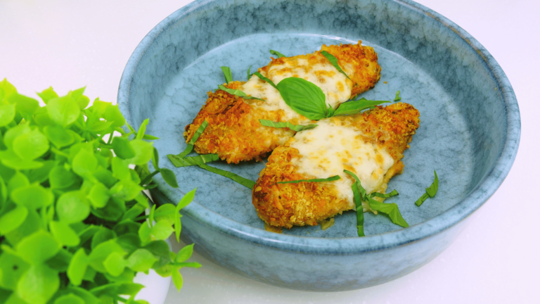 Chicken Alfredo served with sauce and basil, ready to eat.