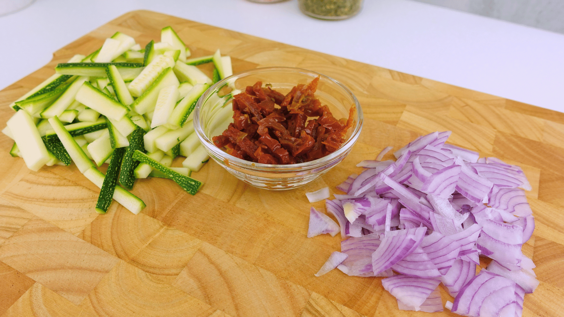 Chopped zucchini, red onion, and sun-dried tomatoes ready for cooking.