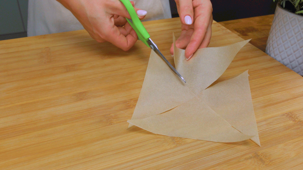Detailed view of cutting parchment paper for muffins.