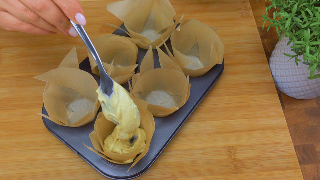Filling muffin liners with batter.