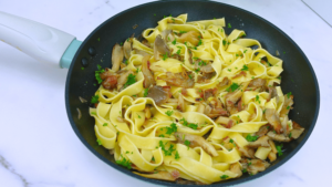 Pasta with mushrooms in a skillet.