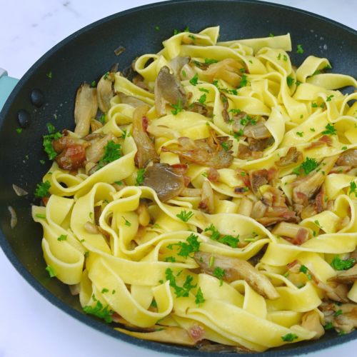 Pasta with mushrooms in a skillet.