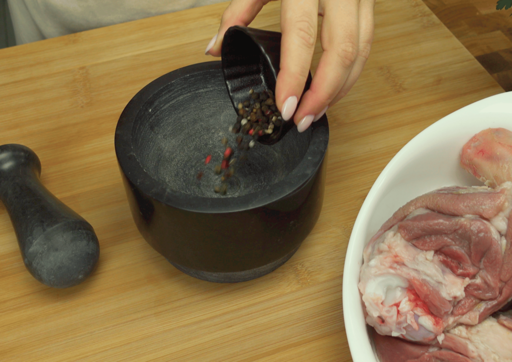 Grinding salt, pepper, and garlic in a mortar for seasoning.