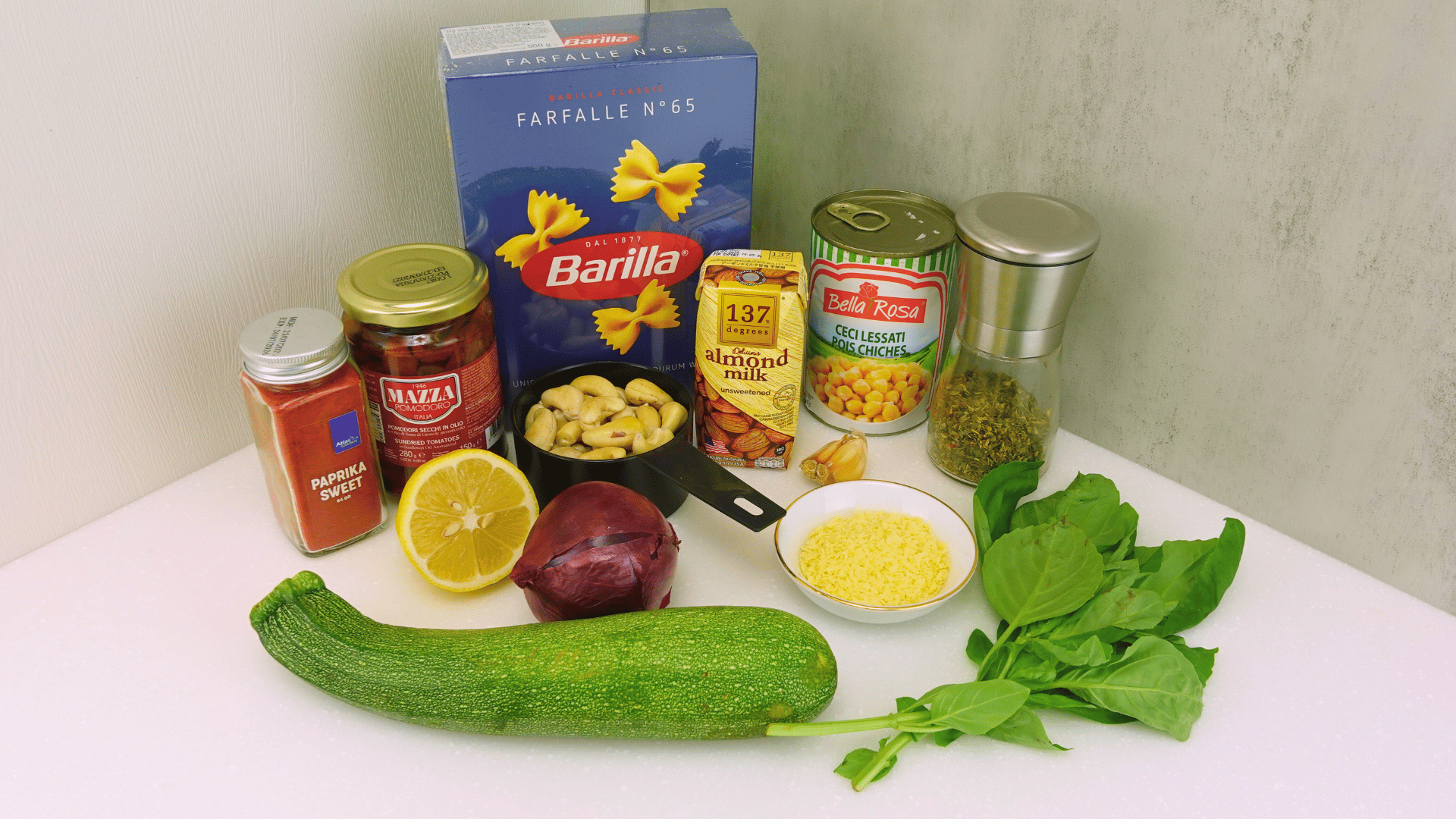 Ingredients for high-protein Vegan Marry Me Pasta, including chickpeas, zucchini, red onion, sun-dried tomatoes, and cashew cream.