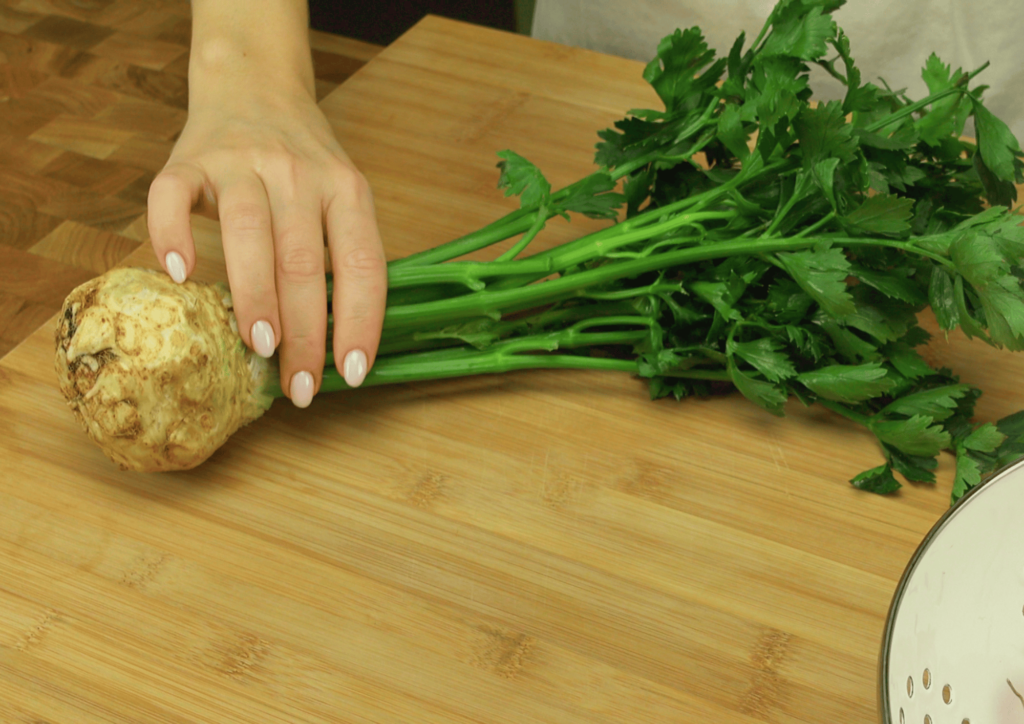 Peeling a fresh celery root for lamb shanks preparation.