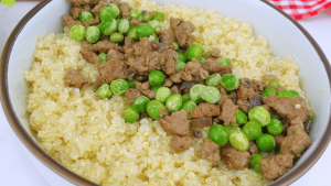 A plate of seasoned ground beef and peas served over rice.