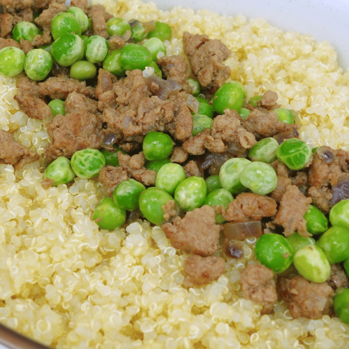 A plate of seasoned ground beef and peas served over rice.