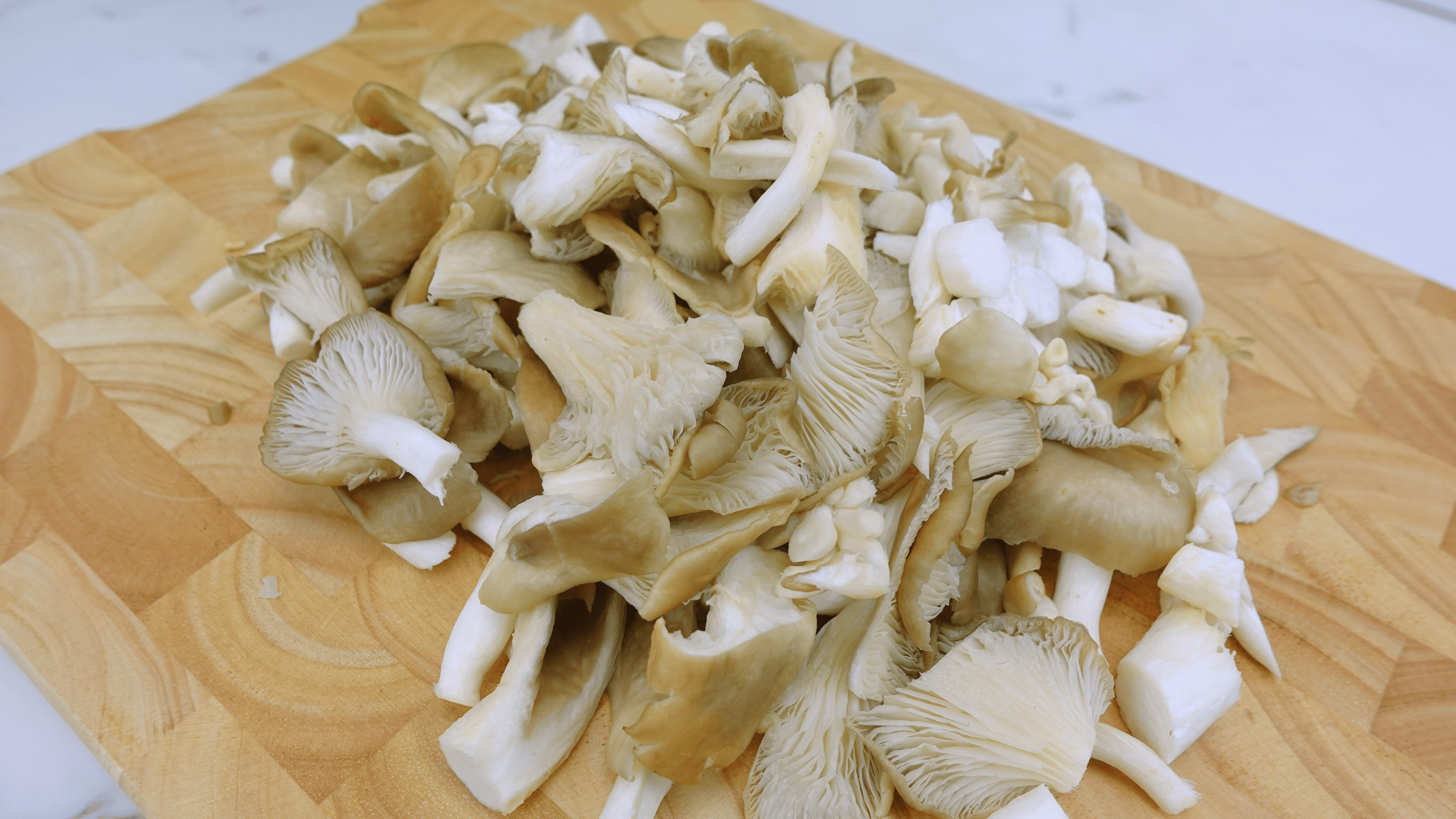 Sliced mushrooms on a cutting board for frying.