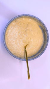 Whisking pancake batter in a mixing bowl with a whisk.