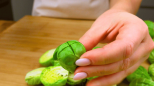 Cutting a cross into the center of Brussels sprouts for even cooking.