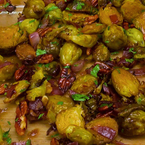 Mixing Brussels sprouts, pecans, and sauce for the final dish.