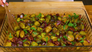 Mixing Brussels sprouts, pecans, and sauce for the final dish.