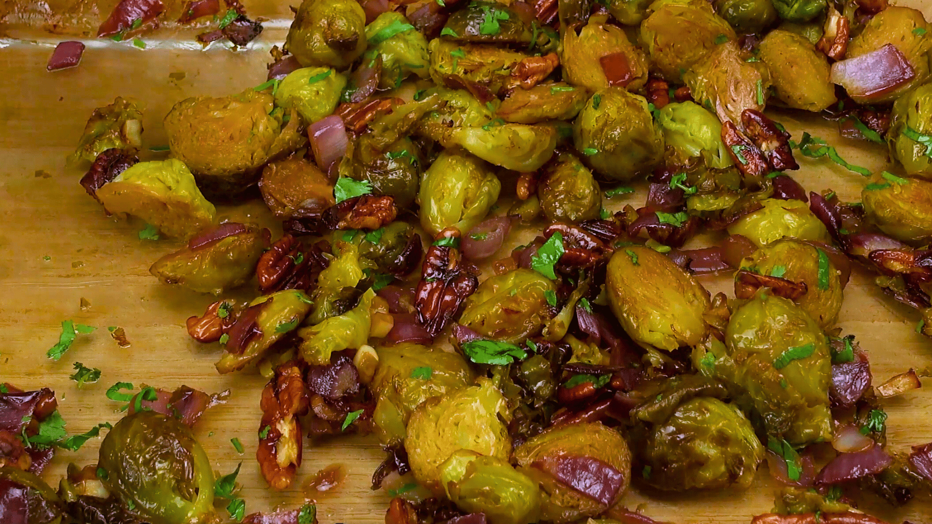 Mixing Brussels sprouts, pecans, and sauce for the final dish.